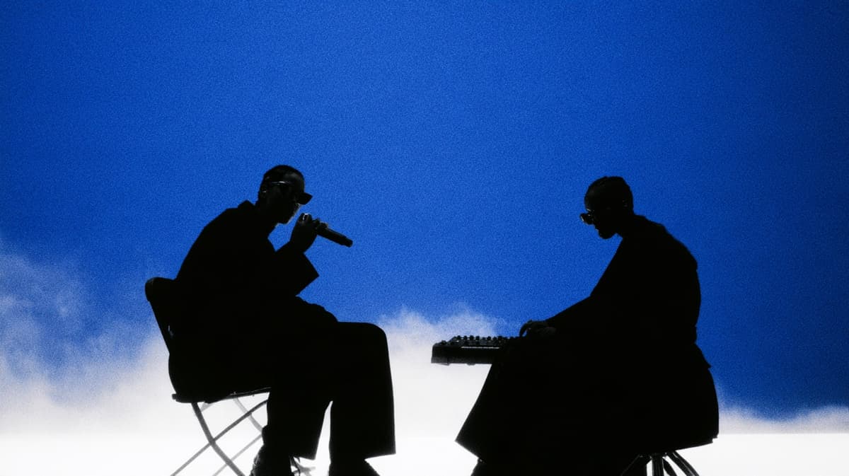 A singer and a keyboard player in silhouette against blue sky